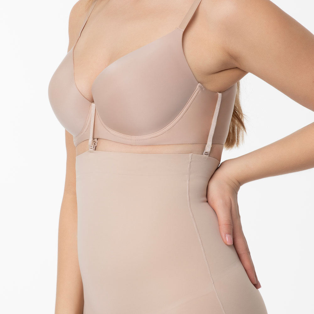 shapewear koriģejošas biksītes ar augsto malu un lentām, kas piestiprinās pie krūštura, uz balta fona, tuvplāns