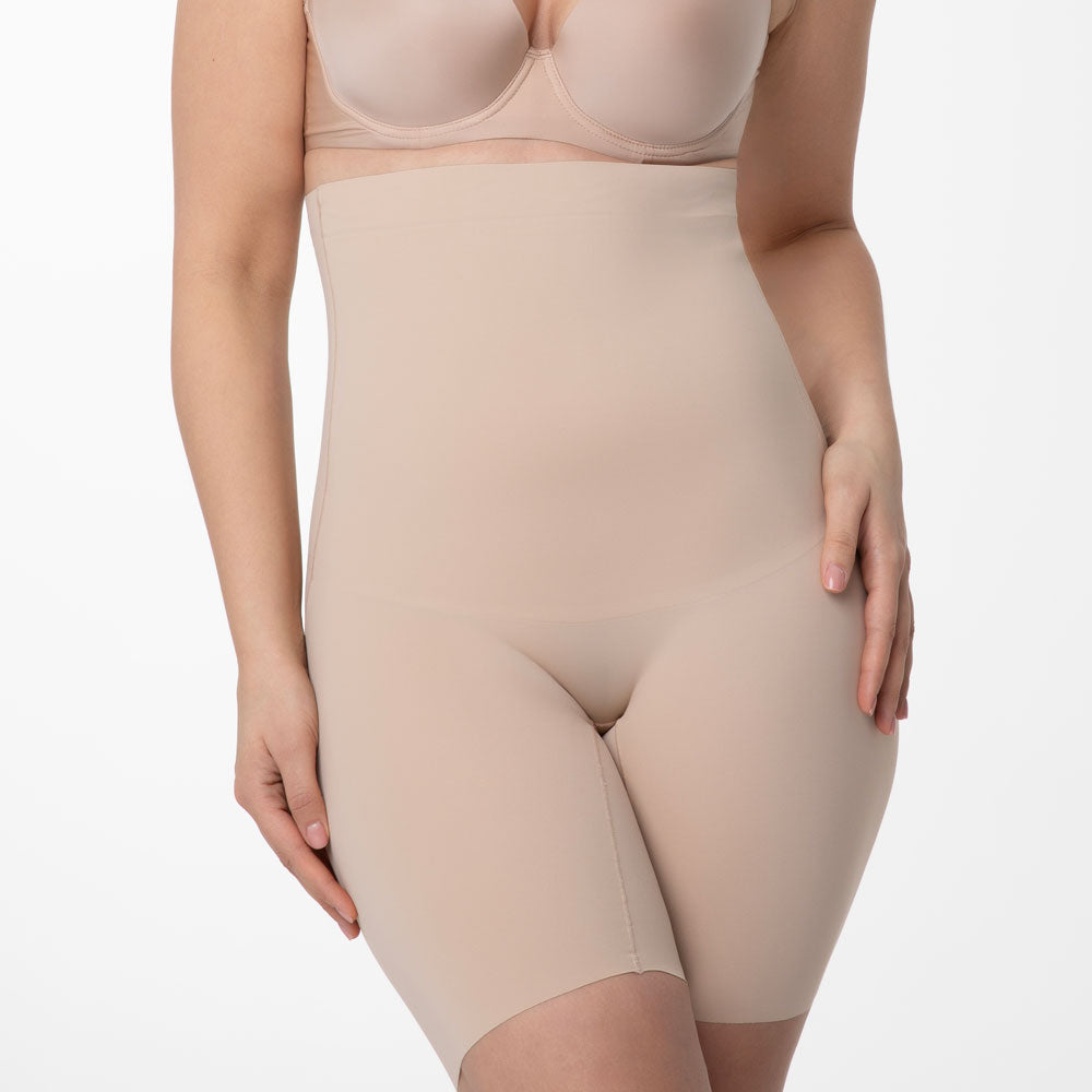 koriģējošs bodijs sievietēm, šorti ar garo malu ap vidukli, miesas. bēša krāsas uz balta fona, no priekšas tuvplāns